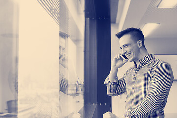 Image showing young business man using smart phone at office