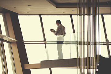 Image showing young successful business man in penthouse apartment working on 