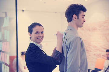 Image showing young couple signing contract documents on partners back