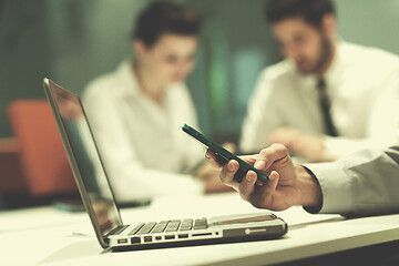 Image showing close up of  businessman hands  using smart phone on meeting