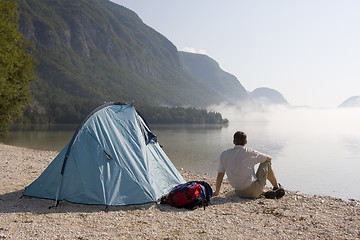 Image showing Man sitting beside a tent