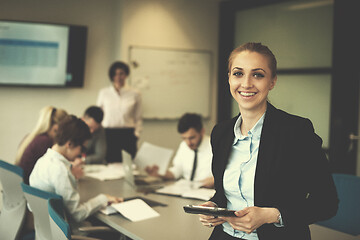 Image showing business woman working on tablet at meeting room