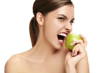 Image showing portrait of attractive caucasian smiling woman isolated on white studio shot eating green apple