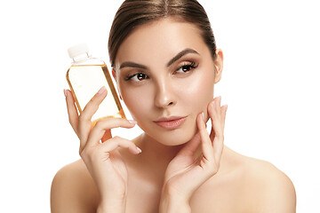 Image showing Beauty concept. The pretty woman with perfect skin holding oil bottle