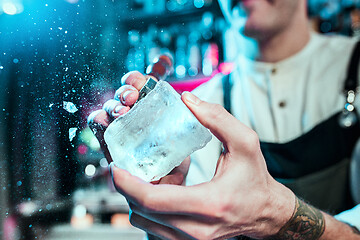 Image showing Expert barman is making cocktail at night club.