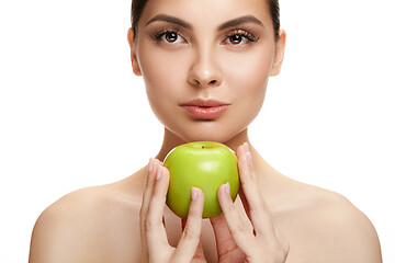 Image showing portrait of attractive caucasian smiling woman isolated on white studio shot eating green apple