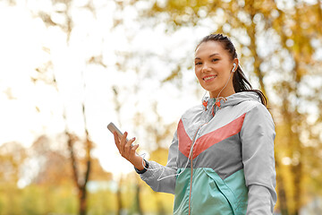 Image showing woman in autumn park and listening to music