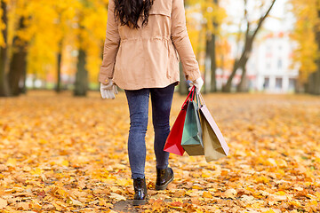 Image showing woman with shopping bags walking along autumn park