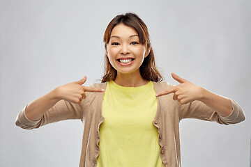 Image showing happy asian woman over grey background