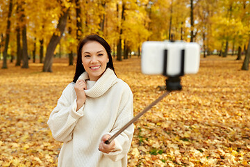 Image showing woman taking selfie by smartphone at autumn park