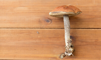 Image showing brown cap boletus mushrooms on wooden background