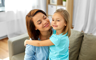 Image showing little daughter hugging her mother at home