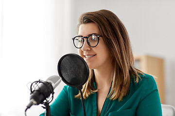 Image showing woman with microphone recording podcast at studio