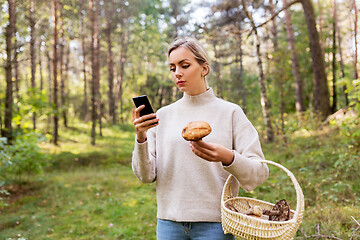 Image showing woman using smartphone to identify mushroom