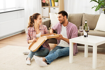 Image showing couple with wine eating takeaway pizza at home