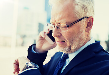 Image showing senior businessman calling on smartphone in city