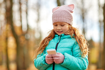 Image showing girl with smartphone at autumn park