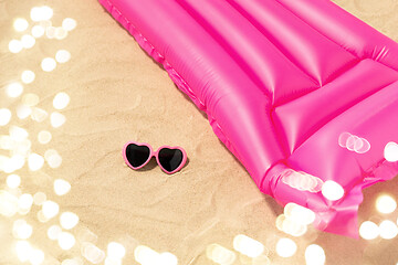 Image showing sunglasses and pink swimming mattress on beach