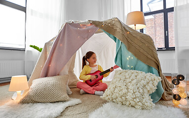 Image showing little girl playing guitar in kids tent at home