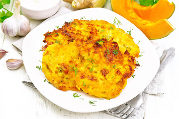 Image showing Pancakes of pumpkin in plate on wooden board