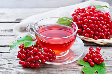 Image showing Tea from viburnum in cup on old wooden board