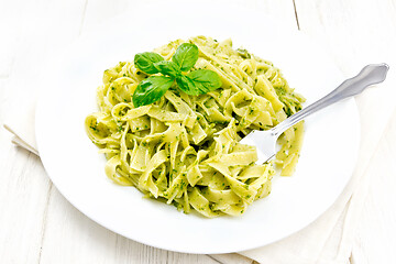 Image showing Pasta with pesto sauce in plate on wooden board