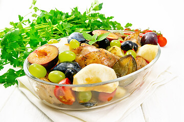 Image showing Chicken with fruits and tomatoes in pan on wooden board