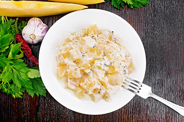 Image showing Pumpkin with sour cream sauce in plate on dark board top