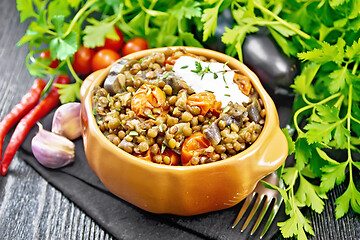 Image showing Lentils with eggplant and tomatoes in bowl on dark board 