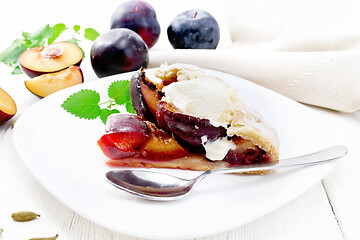 Image showing Galeta with plums in plate on light wooden board