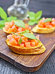 Image showing Bruschetta with tomato and basil on dark board