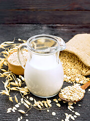 Image showing Milk oatmeal in jug on wooden board