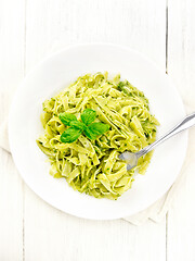 Image showing Pasta with pesto sauce in plate on light board top