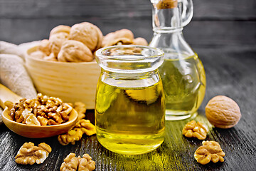 Image showing Oil walnut in jar and decanter on dark board