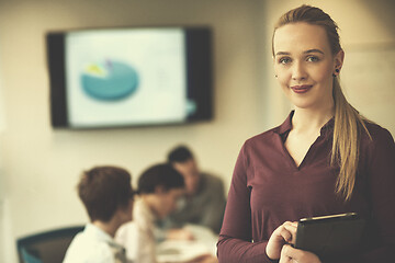 Image showing blonde businesswoman working on tablet at office