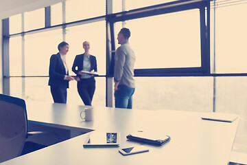 Image showing close up of tablet, business people on meeting in background