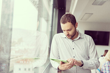 Image showing Businessman Using Tablet In Office Building by window