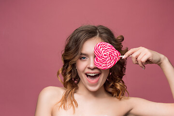 Image showing beauty portrait of a cute girl in act to eat a candy