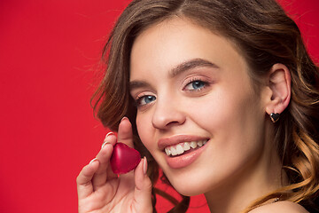 Image showing beauty portrait of a cute girl in act to eat a chocolate candy