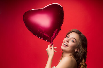 Image showing Nice young smiling woman with long wavy silky hair, natural make up looking at camera