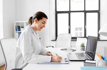 Image showing doctor with laptop and medical report at hospital