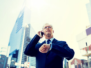 Image showing senior businessman calling on smartphone in city