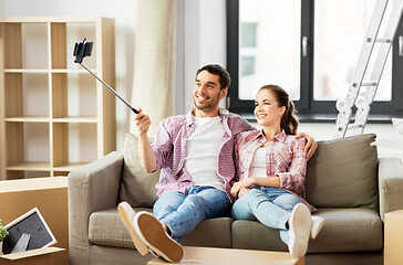 Image showing couple taking picture by selfie stick at new home