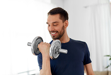 Image showing man exercising with dumbbell at home