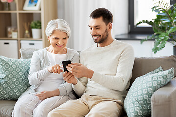 Image showing old mother and adult son with smartphone at home