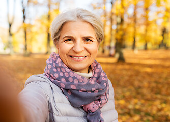 Image showing senior woman taking selfie at autumn park