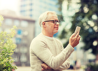 Image showing senior man texting message on smartphone in city