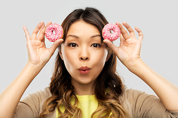 Image showing happy asian woman with donuts