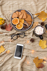 Image showing smartphone, hot chocolate and autumn leaves