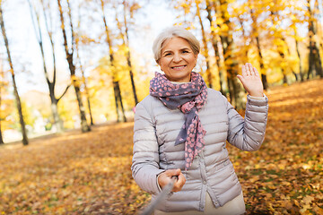 Image showing senior woman taking selfie at autumn park